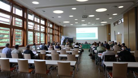 Mitglieder der AG Wolf sitzen in Reihen bie einem Vortrag.